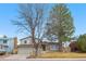 Two-story home with brick accents, attached garage, and mature trees, offering great curb appeal at 3930 S Argonne Way, Aurora, CO 80013