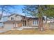 Home's brick and siding exterior with mature trees, two-car garage, and well-manicured lawn at 3930 S Argonne Way, Aurora, CO 80013