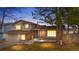 Exterior view of home at dusk featuring brick accents, manicured lawn, and warm lighting at 3930 S Argonne Way, Aurora, CO 80013