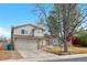 Charming home featuring a brick and siding exterior, mature trees, and a two-car garage at 3930 S Argonne Way, Aurora, CO 80013