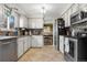 Cozy kitchen with tile floors, light-colored cabinets, stainless steel appliances, and an open view to the dining area at 3930 S Argonne Way, Aurora, CO 80013