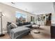 Sunlit living room featuring a plush gray sectional sofa, large window, and easy access to backyard at 3930 S Argonne Way, Aurora, CO 80013