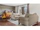 Bright, comfortable living area featuring wood floors, a piano, and large windows with natural light at 3930 S Argonne Way, Aurora, CO 80013