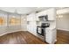 Well-lit kitchen featuring white cabinets, stainless steel appliances, and hardwood floors at 13451 Clermont St, Thornton, CO 80241