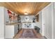 Basement bar with stone countertops, a wine fridge, and wood-look ceiling at 5319 W Hoover Dr, Littleton, CO 80123