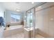 Bright bathroom boasts a glass-enclosed shower and soaking tub with natural light at 5319 W Hoover Dr, Littleton, CO 80123