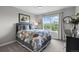 Comfortable bedroom featuring a large window, a cozy bed, and a stylish black dresser at 5319 W Hoover Dr, Littleton, CO 80123