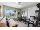 Well-lit bedroom featuring neutral walls, a ceiling fan, and a comfortable sofa under a large window at 5319 W Hoover Dr, Littleton, CO 80123