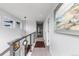 Upstairs hallway with modern railing, neutral paint and carpet, and artwork on the walls at 5319 W Hoover Dr, Littleton, CO 80123