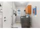 Functional laundry room featuring modern washer and dryer, storage, and tile floors at 5319 W Hoover Dr, Littleton, CO 80123