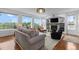Bright living room featuring a stone fireplace, large windows with scenic views, and elegant furnishings creating a cozy ambiance at 5319 W Hoover Dr, Littleton, CO 80123