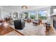 Spacious living area featuring a fireplace, large windows with backyard views, and hardwood floors flowing into adjacent rooms at 5319 W Hoover Dr, Littleton, CO 80123