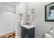 Powder room with blue vanity, modern fixtures and a decorative mirror at 5319 W Hoover Dr, Littleton, CO 80123