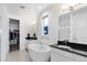 Modern bathroom with dual vanities, a soaking tub, and access to a walk-in closet at 21405 E 59Th Dr, Aurora, CO 80019