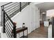 Bright entryway with modern staircase, sleek black railing and hardwood floors leading to the kitchen at 21405 E 59Th Dr, Aurora, CO 80019