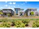 Modern home with landscaped yard, gated fence and exterior balcony in a neighborhood setting under a blue sky at 21405 E 59Th Dr, Aurora, CO 80019