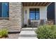 Inviting front porch with seating area, stone accents and modern details for relaxing outdoor enjoyment at 21405 E 59Th Dr, Aurora, CO 80019