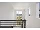 Bright hallway with large windows offering views of the neighborhood, framed by black iron railing at 21405 E 59Th Dr, Aurora, CO 80019