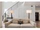 Open-concept living room with modern lighting, staircase with black railings and neutral colored couch at 21405 E 59Th Dr, Aurora, CO 80019
