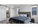 Bedroom featuring a king bed, rug, and an ensuite bathroom with barn door access at 21405 E 59Th Dr, Aurora, CO 80019