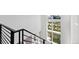 Modern staircase featuring sleek black railings and sunlit views at 21405 E 59Th Dr, Aurora, CO 80019