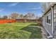 Large backyard features lush green grass, mature trees, and a detached brick garage at 3075 Fairfax St, Denver, CO 80207