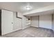Finished basement area with neutral carpet, white walls, built in shelving, and closet space at 3075 Fairfax St, Denver, CO 80207