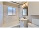 Bright bathroom featuring subway tile, window above tub, and updated vanity at 3075 Fairfax St, Denver, CO 80207