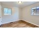 A bedroom with hardwood floors and neutral walls with two windows at 3075 Fairfax St, Denver, CO 80207