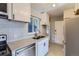 A kitchen with white cabinets, stainless steel appliances, and a mosaic backsplash at 3075 Fairfax St, Denver, CO 80207