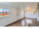Spacious sun room with wood-look vinyl flooring, white wood panel walls, and natural light at 3075 Fairfax St, Denver, CO 80207