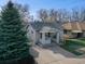 Well-maintained home with a covered front porch and a neatly landscaped yard with a large evergreen tree at 3225 S Lincoln St, Englewood, CO 80113
