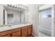 Bright bathroom features a double sink vanity, a large mirror with decorative lighting, and a shower-tub combo at 8237 W 54Th Ave # 2, Arvada, CO 80002