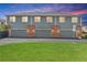 Rear view of building highlighting three garages with well-maintained lawns and driveway at 8237 W 54Th Ave # 2, Arvada, CO 80002