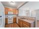 Practical kitchen with white appliances, wooden cabinets, and convenient breakfast bar at 8237 W 54Th Ave # 2, Arvada, CO 80002