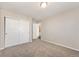 A bright bedroom with neutral walls, plush carpeting, and a closet with modern white doors at 17717 E 54Th Ave, Denver, CO 80249