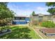 Backyard featuring a covered porch, greenhouse, mature trees and grassy area at 3306 S Logan St, Englewood, CO 80113