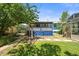 Backyard featuring a covered porch, greenhouse, and mature landscaping at 3306 S Logan St, Englewood, CO 80113