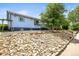 Charming exterior view of blue home with rock landscaping and wooden stairs at 3306 S Logan St, Englewood, CO 80113