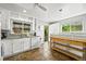 Well-lit kitchen featuring white cabinets, granite counters, and a tiled floor at 3306 S Logan St, Englewood, CO 80113
