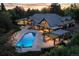 Stunning aerial view of a luxury home with a pool, outdoor kitchen, and patio at sunset at 1328 E Layton Ave, Cherry Hills Village, CO 80113