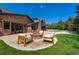 Expansive backyard featuring a brick patio with fire pit, manicured lawn, and pool with lush landscaping at 1328 E Layton Ave, Cherry Hills Village, CO 80113