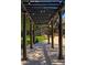 An open air pergola with lights, brick house in the background with manicured lawn and landscaped yard at 1328 E Layton Ave, Cherry Hills Village, CO 80113