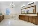 Bright bathroom features a soaking tub, wooden vanity, and contemporary lighting fixture at 1328 E Layton Ave, Cherry Hills Village, CO 80113