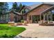 Exterior of a brick home with a patio, fire pit, and manicured lawn at 1328 E Layton Ave, Cherry Hills Village, CO 80113