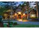 Elegant brick home featuring a grand arched entrance and lush landscaping at 1328 E Layton Ave, Cherry Hills Village, CO 80113