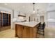 This kitchen boasts a large center island with seating, custom cabinetry, and modern pendant lighting at 1328 E Layton Ave, Cherry Hills Village, CO 80113