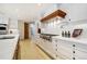 Gourmet kitchen features a professional-grade range, custom hood, white cabinets, and quartz countertops at 1328 E Layton Ave, Cherry Hills Village, CO 80113