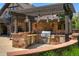 View of an outdoor kitchen with a stainless steel grill and stone surround at 1328 E Layton Ave, Cherry Hills Village, CO 80113