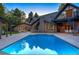 Backyard pool with a brick house, manicured lawn, spiral staircase, and pergola with outdoor seating at 1328 E Layton Ave, Cherry Hills Village, CO 80113